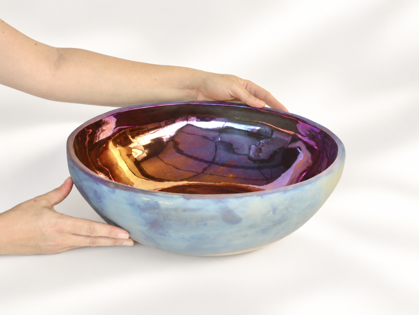 Large iridescent ceramic bowl with hands